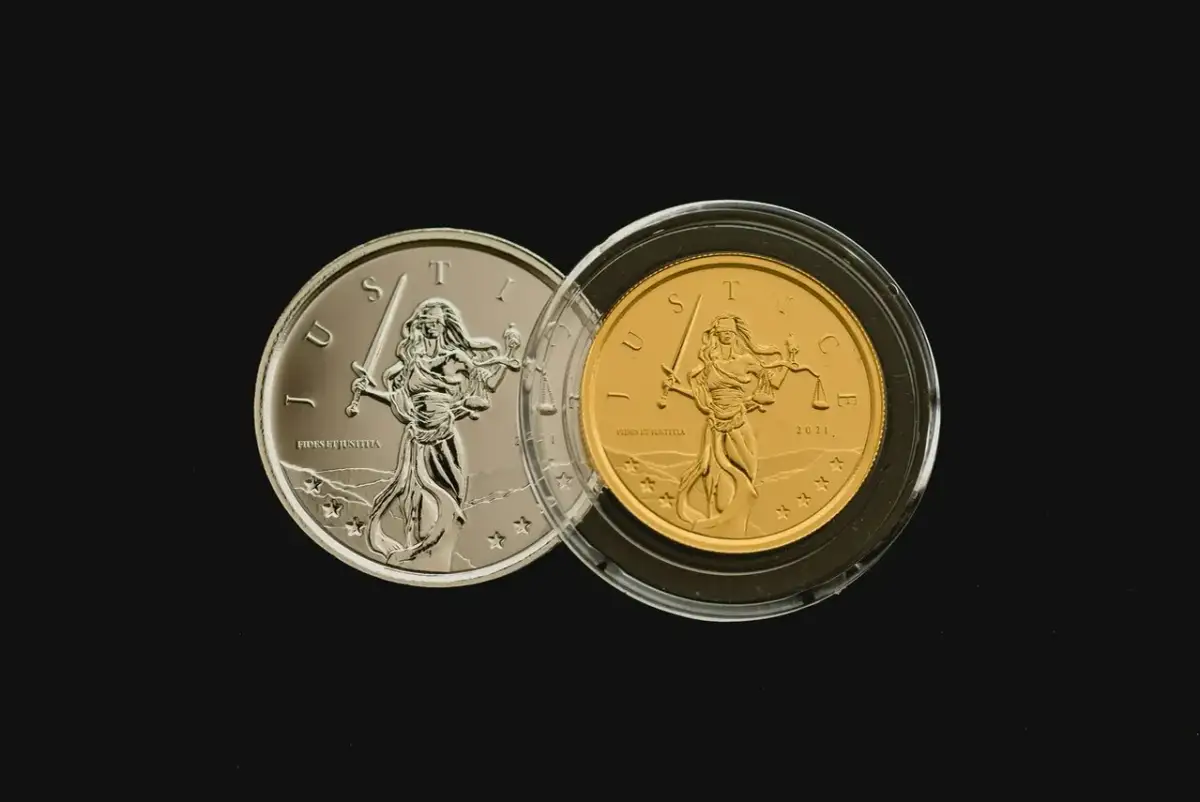 Dwie monety inwestycyjne: srebrna i złota, z Justycją. Zastanawiasz się, jakie monety inwestycyjne kupować?