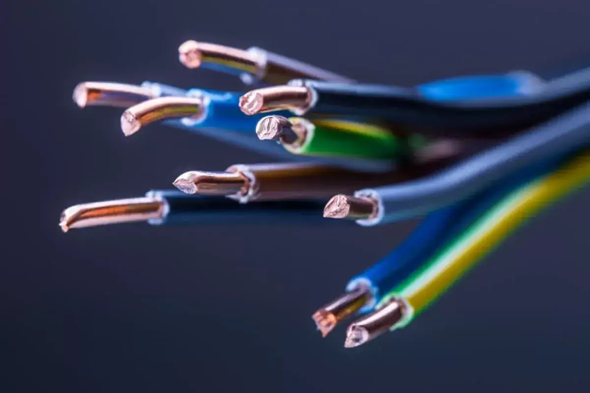 Miedziane żyły kabli elektrycznych, które są świetnym przewodnikiem, wystają z kolorowych izolacji.