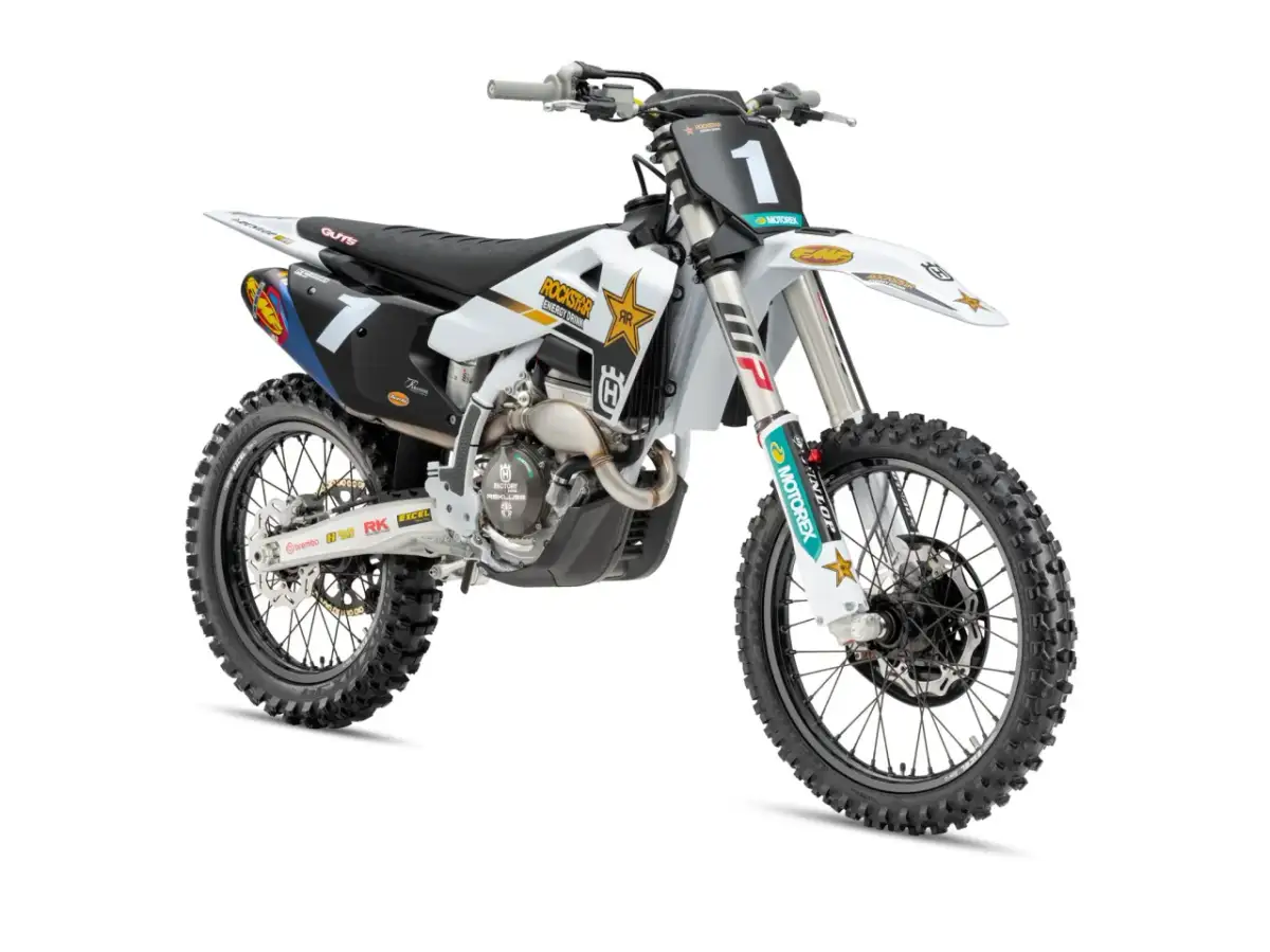Biały motocykl Husqvarna 250 cross z numerem 1 na tablicy, ozdobiony logotypami Rockstar Energy i Motorex.