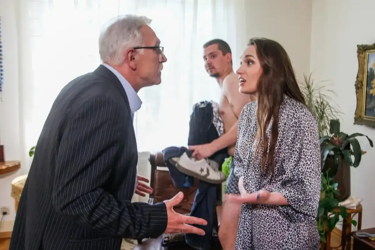 Trzech ludzi w pokoju, starszy mężczyzna w garniturze kłóci się z młodą kobietą, podczas gdy młody mężczyzna stoi za nimi. Czy ukryta prawda jest na faktach?