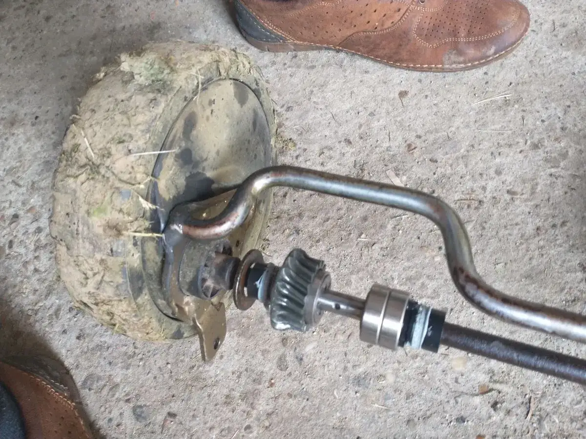 Zepsuty napęd kosiarki, koło pokryte ziemią. Zastanawiasz się, ile kosztuje naprawa napędu w kosiarce?