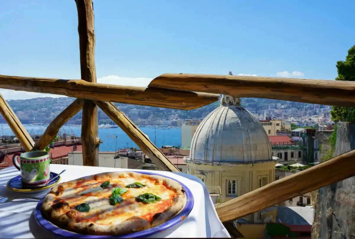 Smakowita pizza i kawa na tarasie z widokiem na Neapol. Ceny we Włoszech mogą być różne, ale takie widoki są bezcenne.