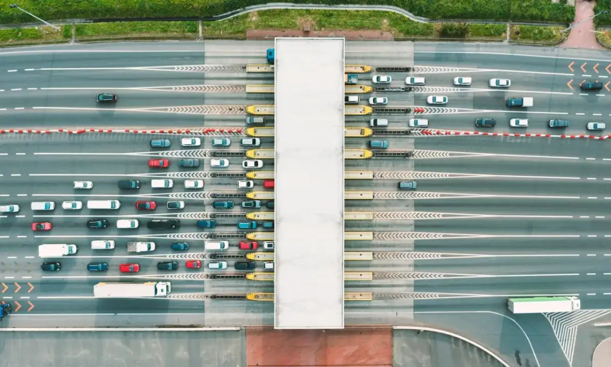Widok z lotu ptaka na szlabany autostradowe z kolejkami samochodów i ciężarówek.