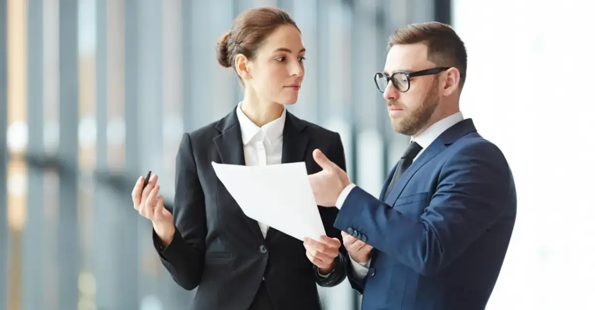 Biznesmeni dyskutują o tym, ile wynosi dzienna dieta w delegacji, analizując dokumenty.