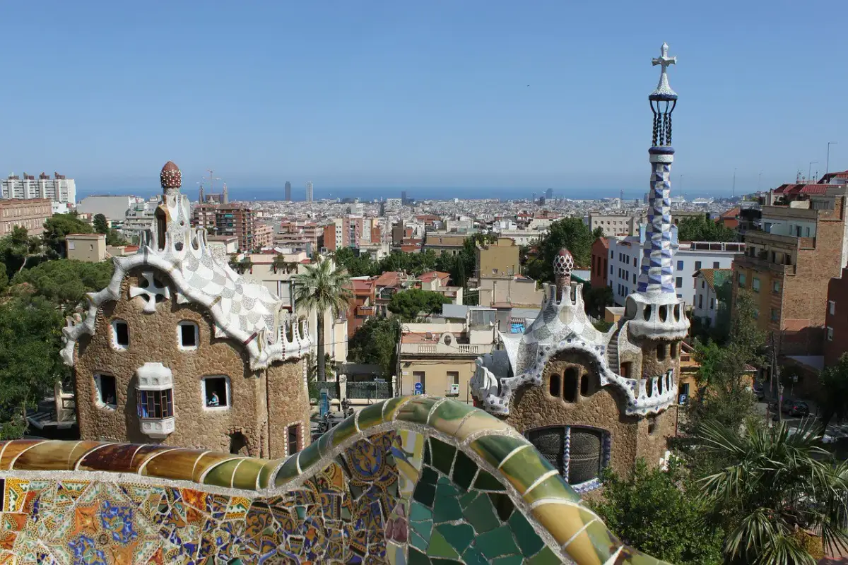 Widok na Park Güell w Barcelonie, z mozaikowymi budynkami i panoramą miasta. Ceny w Barcelonie mogą być wysokie, ale widoki są bezcenne.