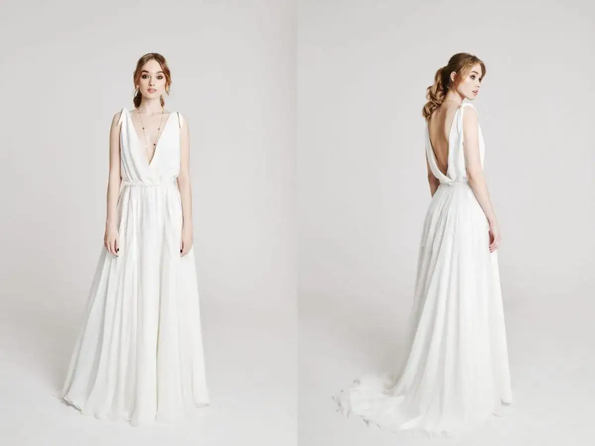 Elegancka, biała suknia ślubna z głębokim dekoltem i odkrytymi plecami. Zastanawiasz się, ile kosztuje uszycie sukni ślubnej?