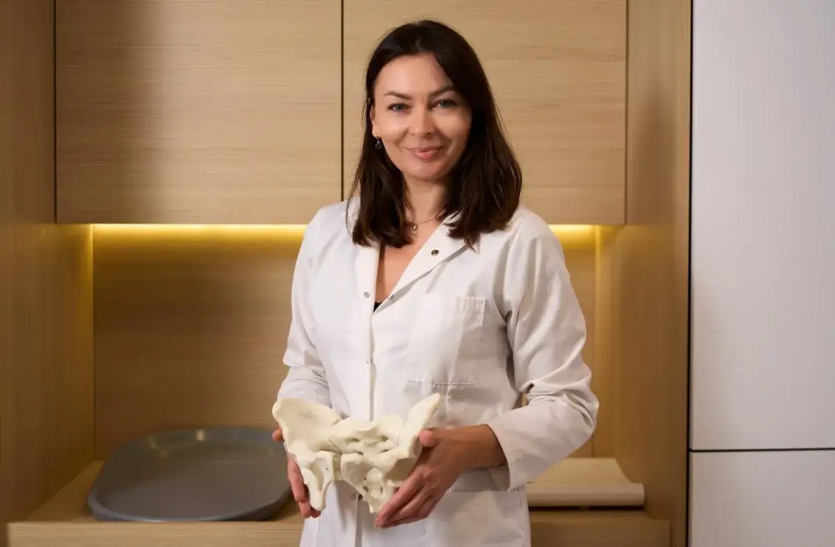 Położna środowiskowa z modelem miednicy, gotowa odpowiedzieć na Twoje pytania.