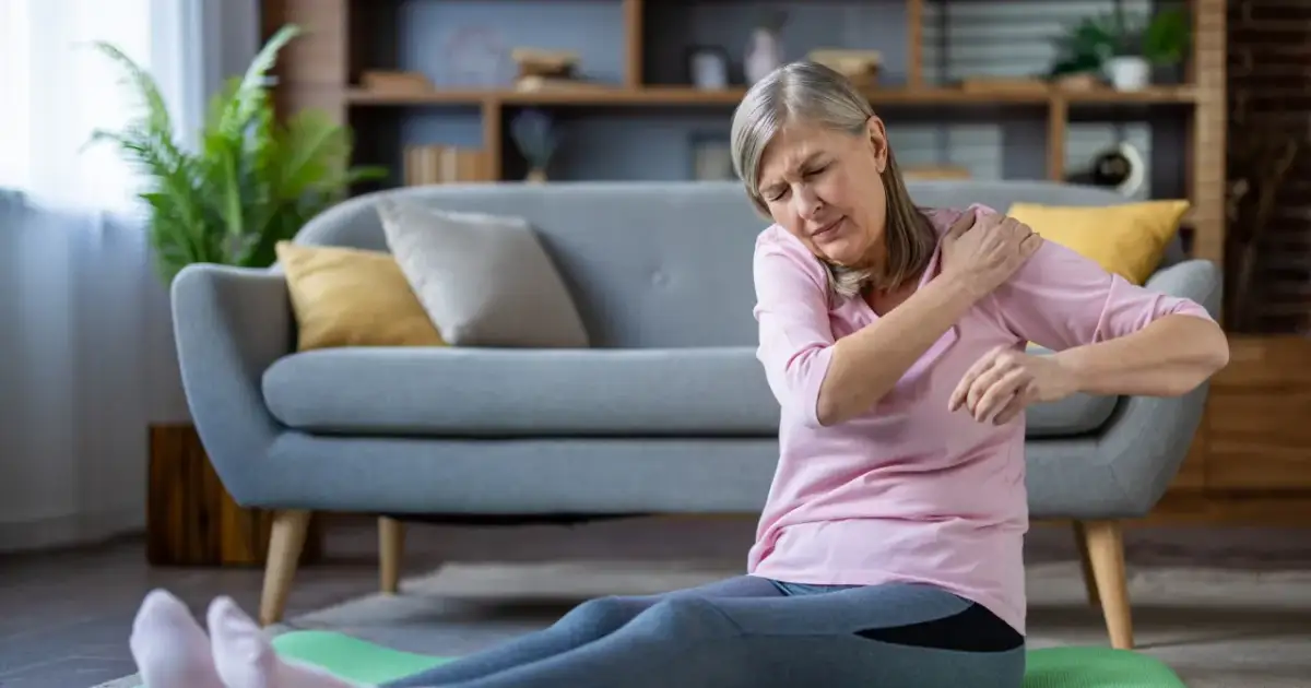 Starsza kobieta z bólem ramienia po treningu zastanawia się, czy zakwasy po treningu są dobre.