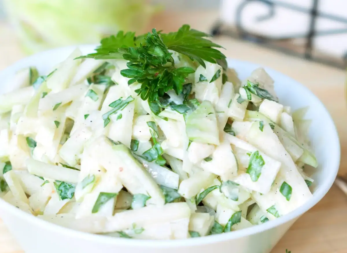 Pyszna surówka z kalarepy, pokrojona w słupki, z dodatkiem natki pietruszki i kremowego sosu. Idealna na lekki posiłek.