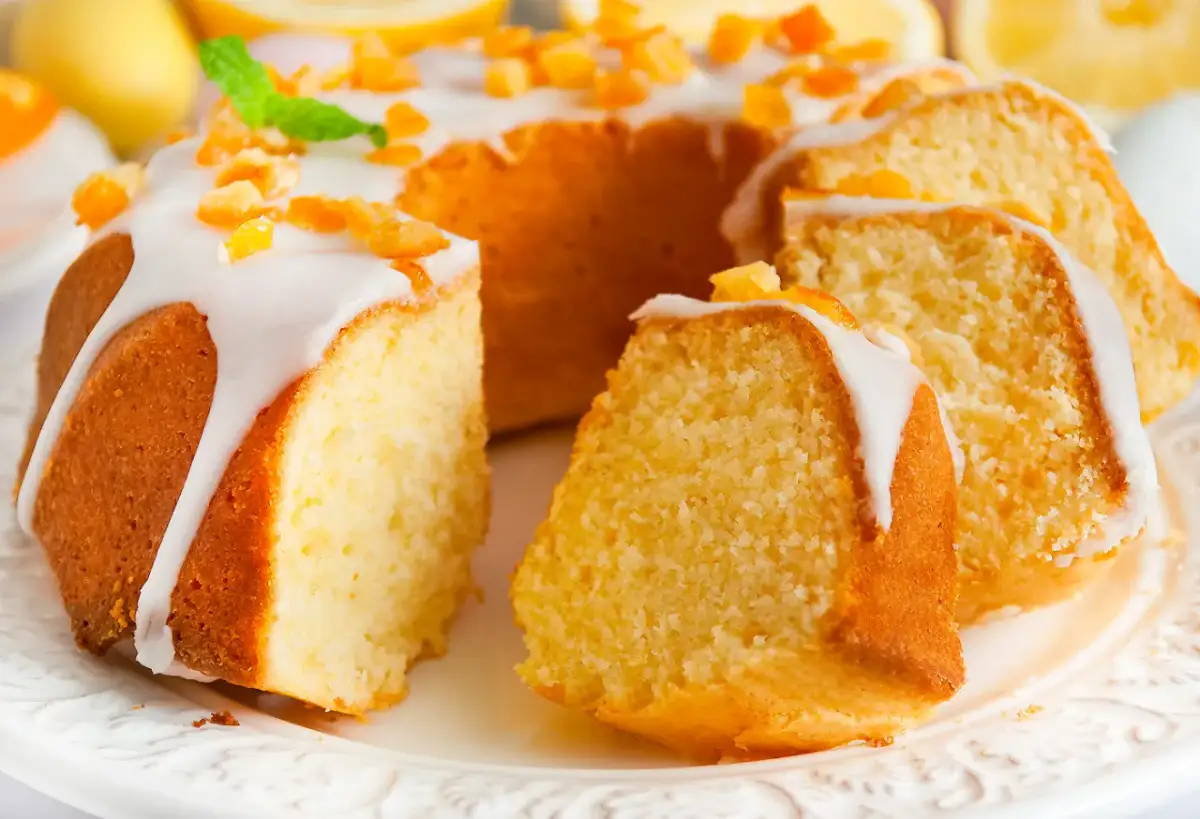 Puszysta babka wielkanocna cytrynowa, polana lukrem i posypana kandyzowaną skórką cytrynową, prezentuje się apetycznie.