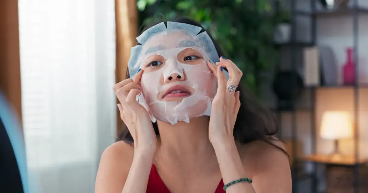 Kobieta poprawia maseczkę na noc, przygotowując skórę do regeneracji.