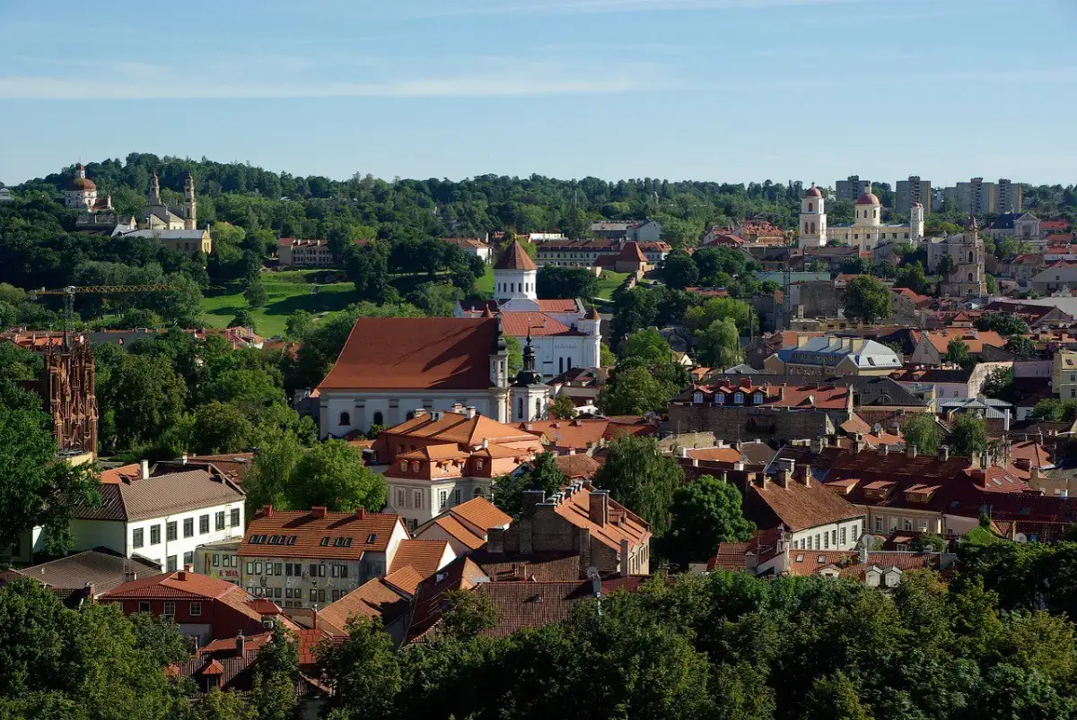 Widok na Wilno z licznymi kościołami i zielenią. Czy na Litwie jest drogo? Tutejsze zabytki i urokliwe uliczki mogą zachęcić do odwiedzin.