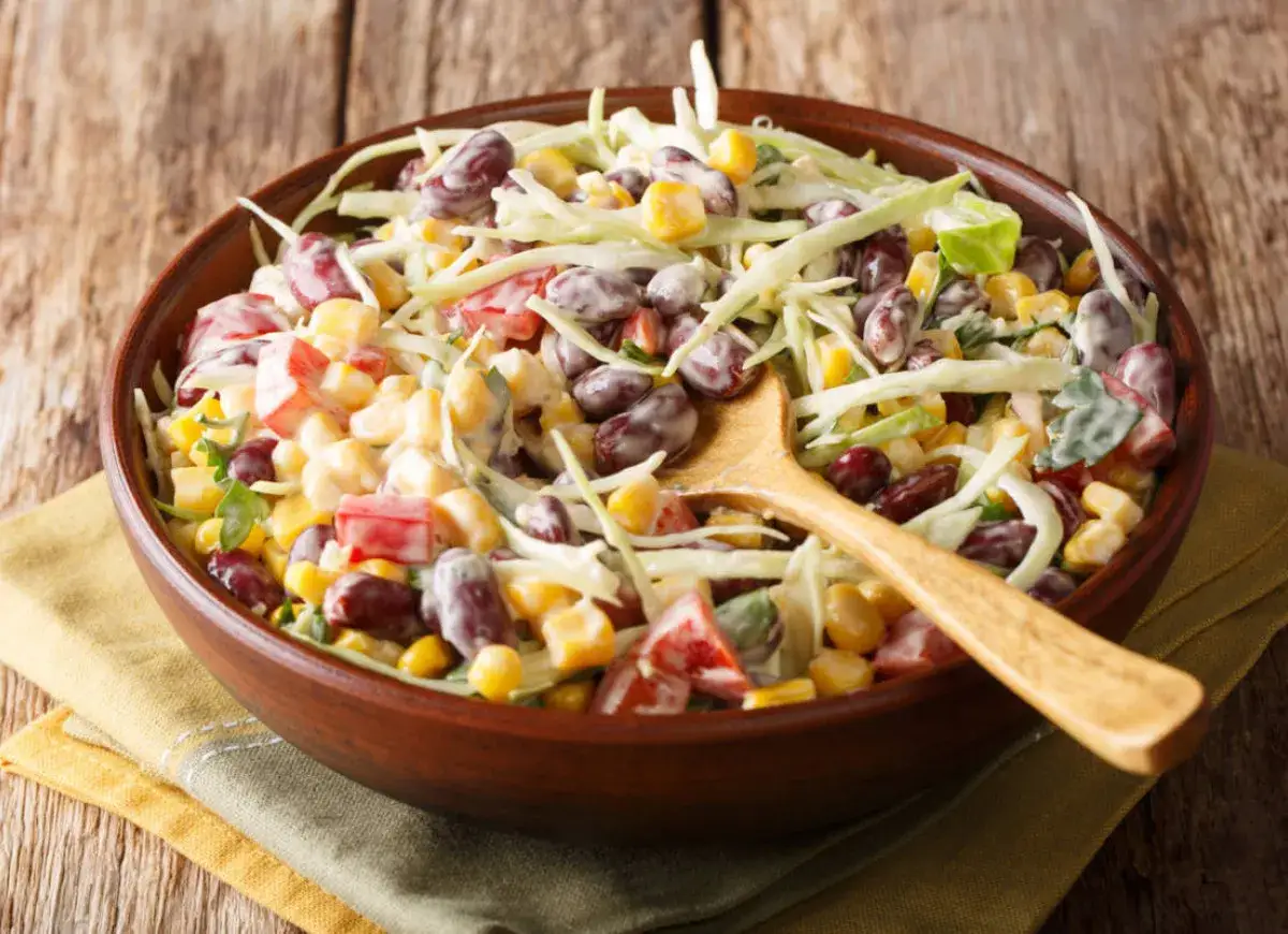 Kolorowa sałatka z czerwoną fasolą, kukurydzą i poszatkowaną kapustą, polana kremowym sosem. Idealna na letnie dni.