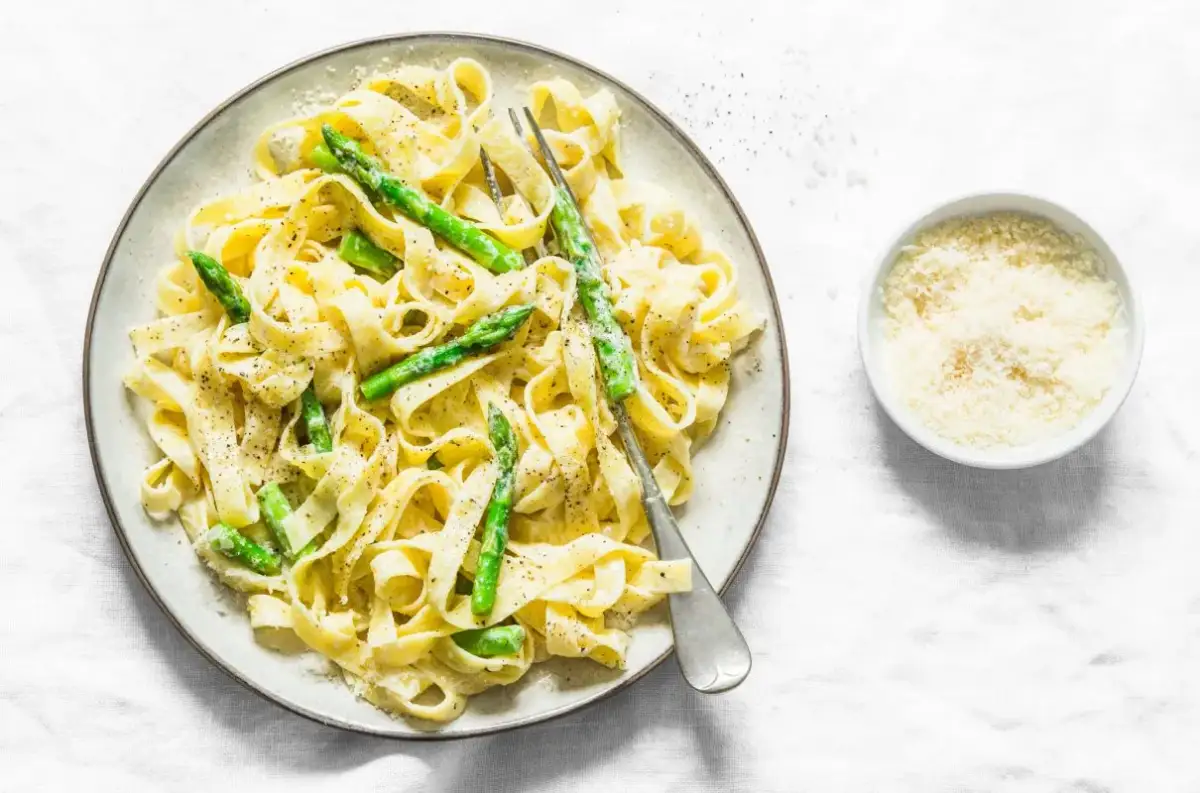 Pyszny makaron ze szparagami, polany kremowym sosem i posypany parmezanem. Idealny na wiosenny obiad.