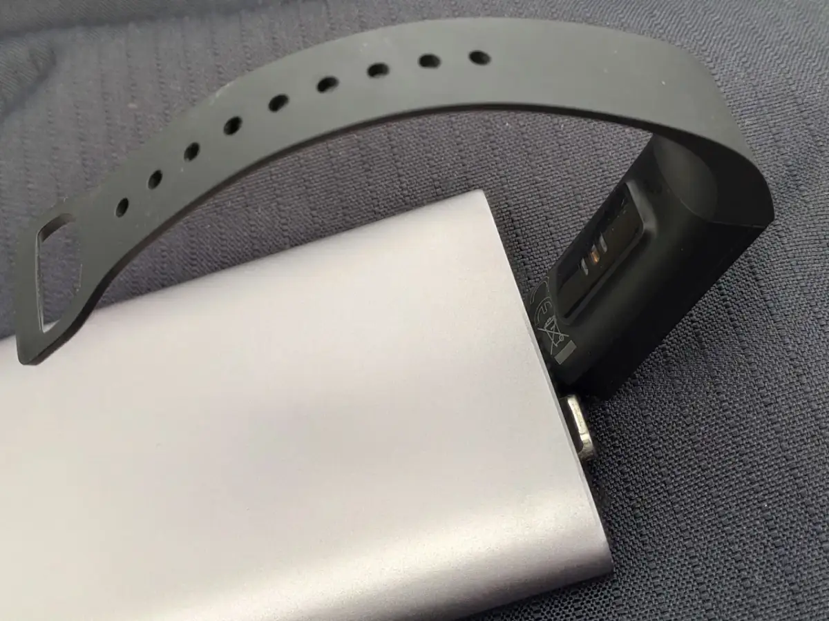 Smartband podłączony do powerbanka, pokazujący, jak ładować smartwatch bez ładowarki.