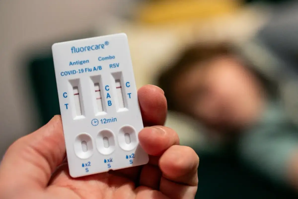 Test na grypę i COVID-19. Dwa paski na teście wskazują pozytywny wynik.