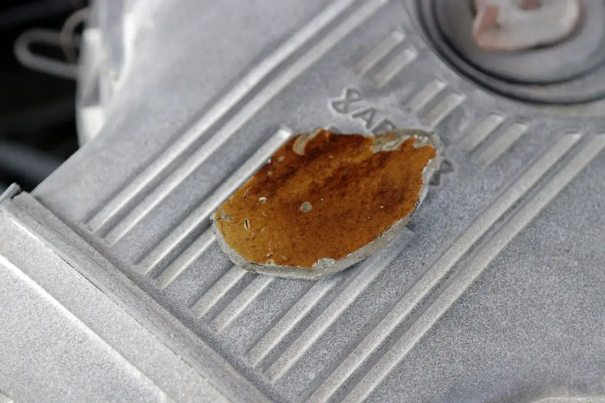 Fragment metalowej części silnika z widocznymi śladami rdzy i uszkodzeń, mogącymi wskazywać na objawy zatarcia silnika.