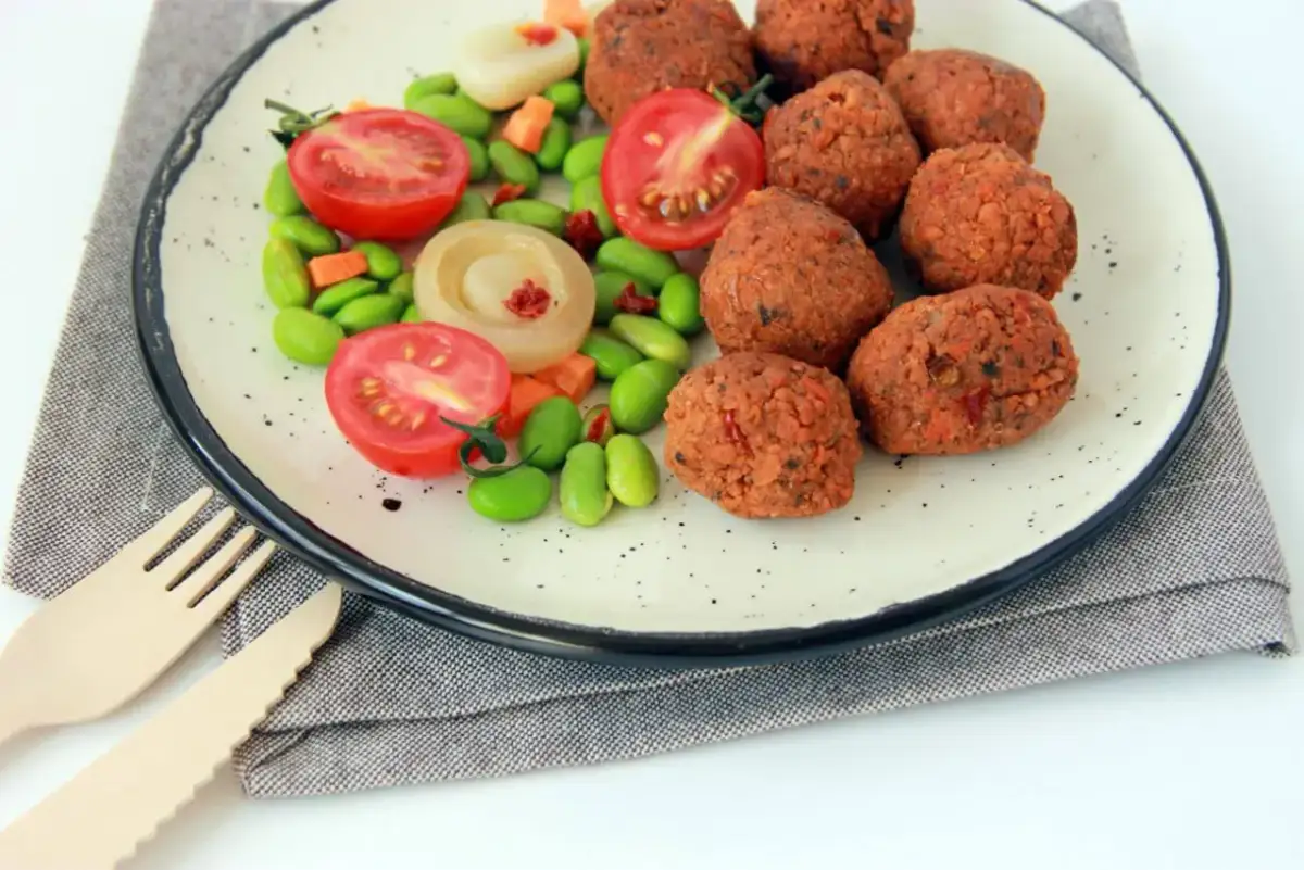 Talerz z kotletami sojowymi, pomidorkami, edamame i marchewką. Czy kotlety sojowe są zdrowe? Wyglądają apetycznie!