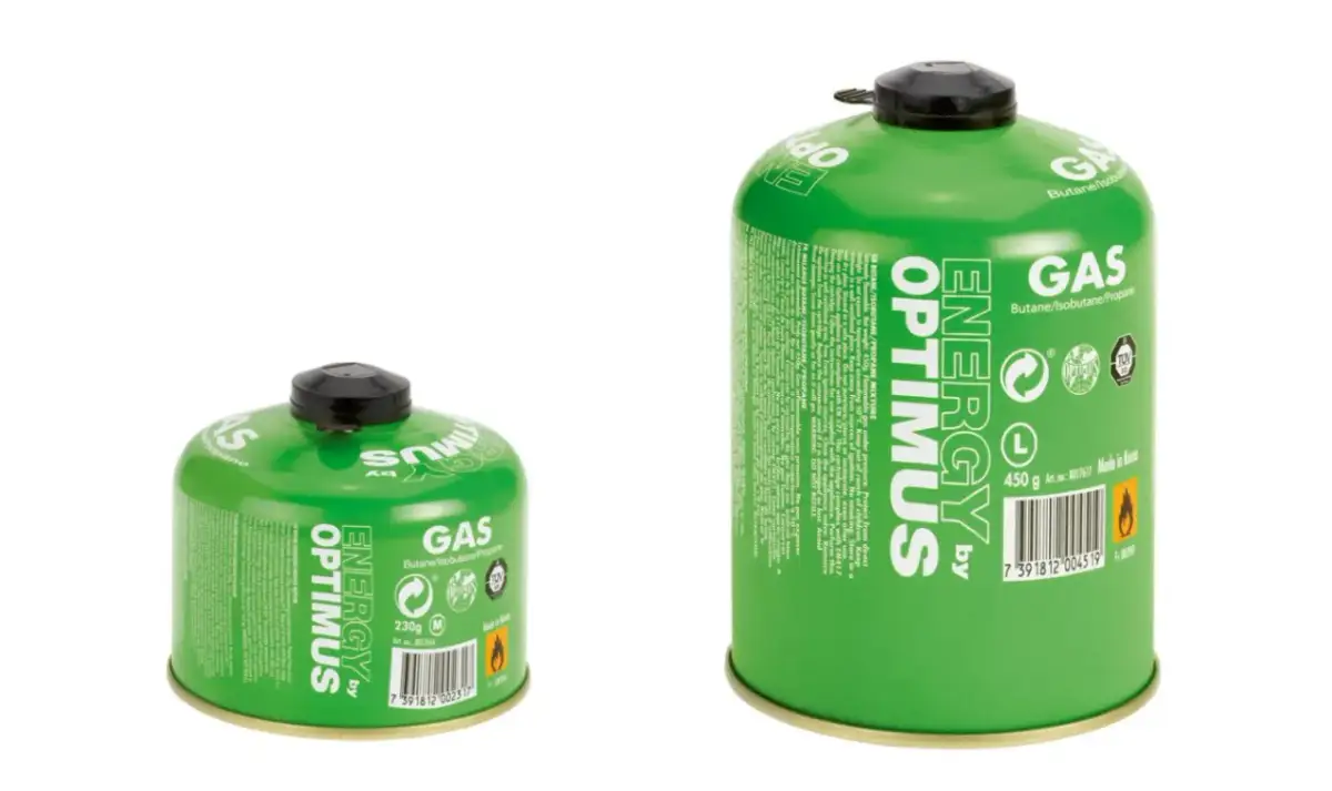 Dwa zielone kartusze z gazem, jeden mniejszy (230g) i jeden większy (450g), gotowe do przechowywania w domu lub zabrania na wycieczkę.
