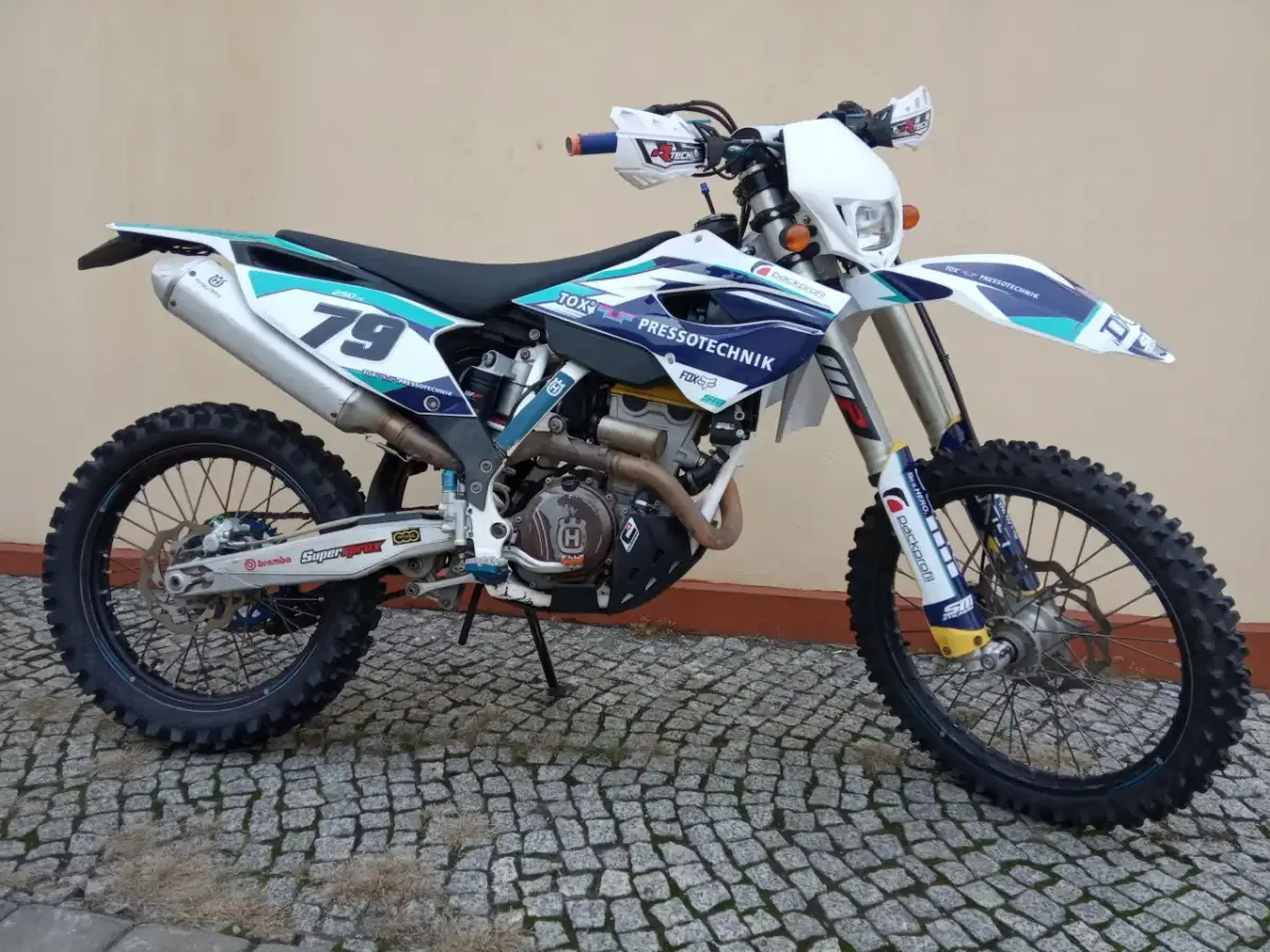 Husqvarna 250 FE z numerem 79, gotowy do akcji na wyboistym terenie.