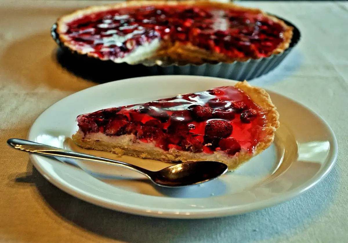Pyszna tarta z mascarpone i owocami w galaretce, z łyżeczką gotową do degustacji.