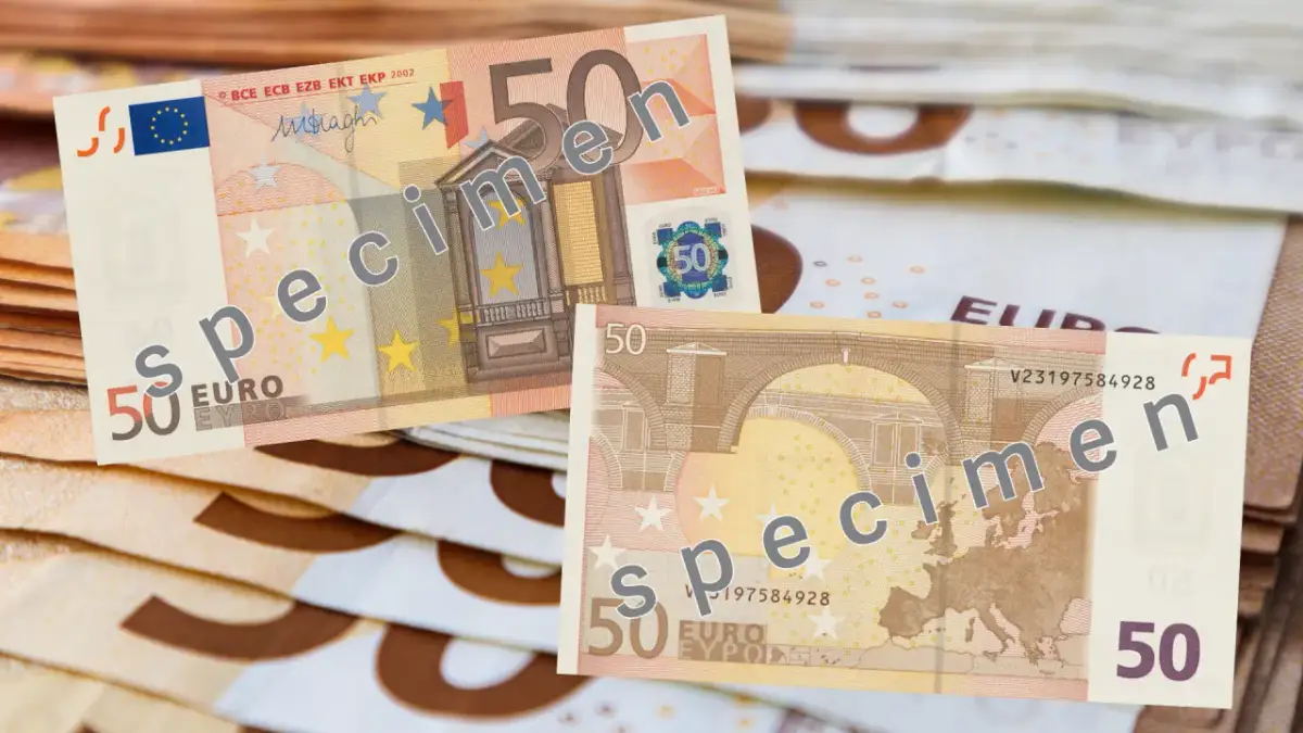 Banknoty 50 euro, oznaczone jako "specimen", leżą na stosie innych banknotów.