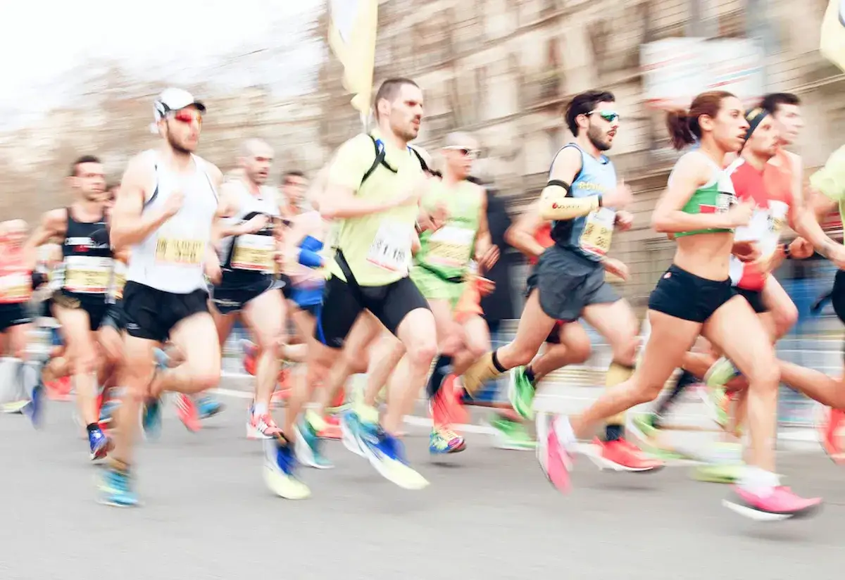 Course de marathon avec des coureurs en mouvement, certains portant des dossards.