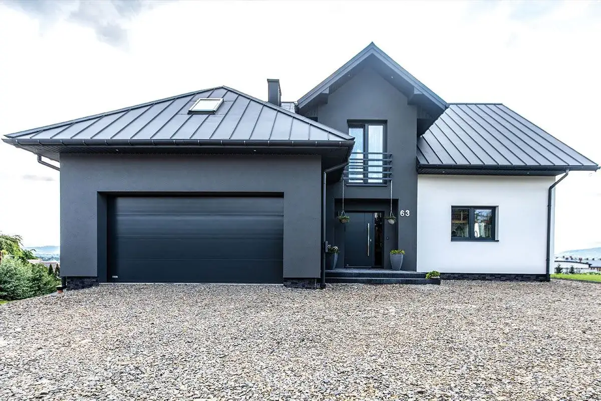 Nowoczesny dom z garażem i czarnym dachem. Czy blachodachówkę można odliczyć od podatku? Zapytaj doradcę!