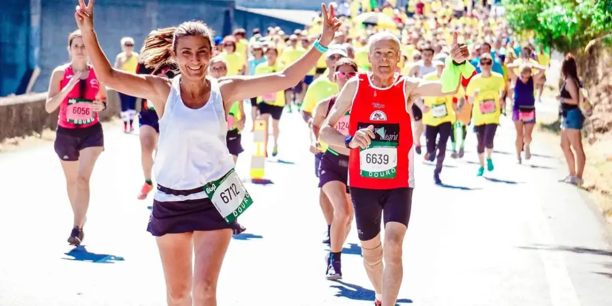 Uśmiechnięci biegacze na maratonie, radość i determinacja. Jak przygotować się do maratonu? Warto czerpać inspirację z ich pozytywnej energii!