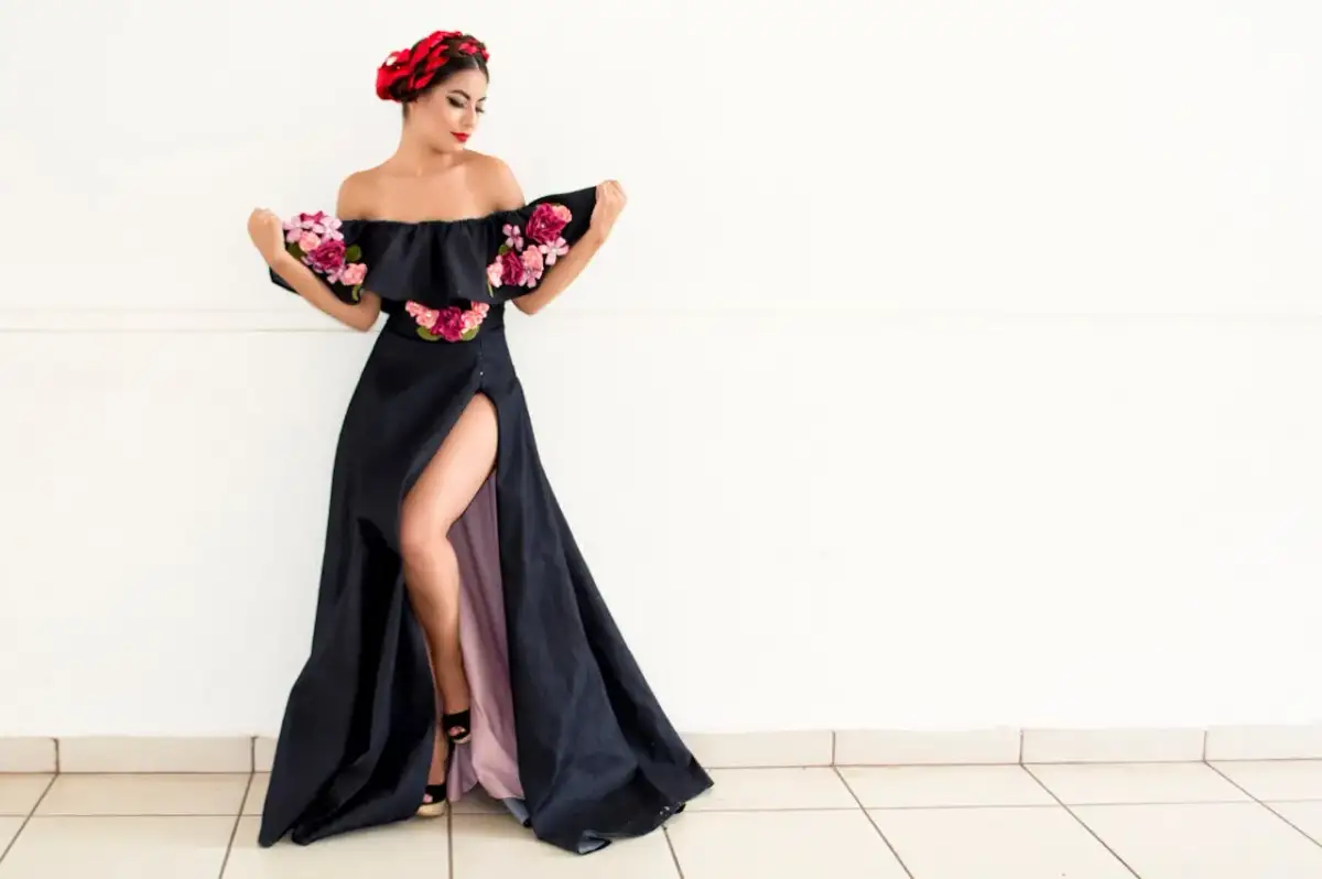 Elegancka czarna suknia z rozcięciem i kwiatami. Inspiracja dla mężczyzny, jak się ubrać na rocznicę ślubu jako gość.