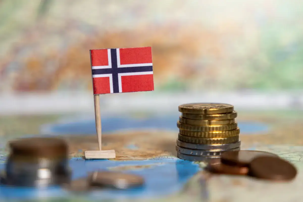Norweska flaga na mapie obok stosu monet.