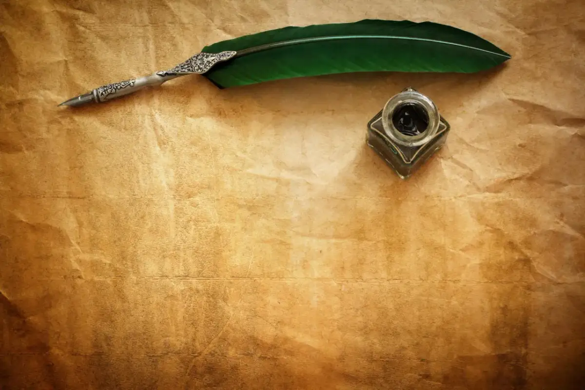 Pióro i kałamarz na pożółkłym papierze, gotowe do spisania hymnu do miłości ojczyzny.