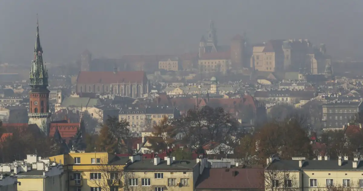 Mglisty widok Krakowa z wieżą kościelną i zamkiem. Warto wiedzieć, jak chronić się przed zanieczyszczeniami powietrza w takich warunkach.