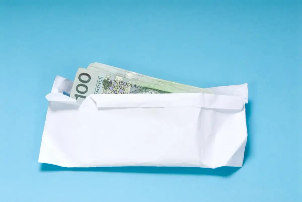 Koperta z banknotami 100 zł. Zastanawiasz się, ile pieniędzy daje się na 18 urodziny?
