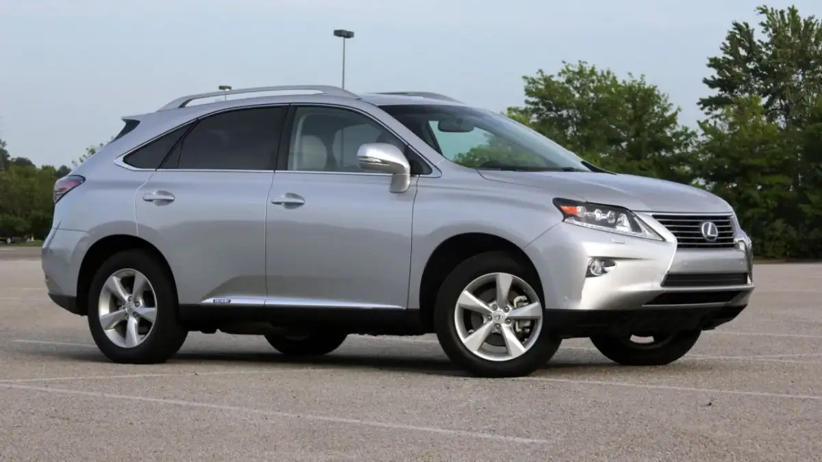 Srebrny Lexus RX 450h, jeden z najmniej awaryjnych SUV-ów 10-letnich, zaparkowany na placu.