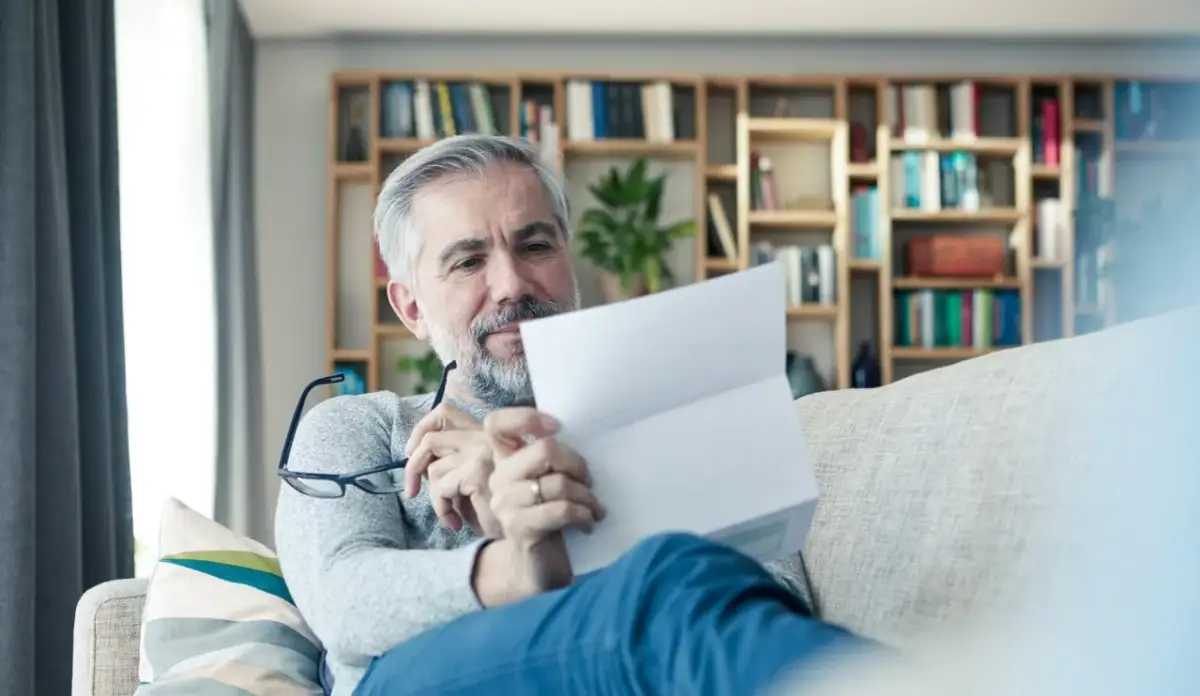 Mężczyzna czyta dokument, zastanawiając się, czym jest ubezpieczeniowy fundusz gwarancyjny.