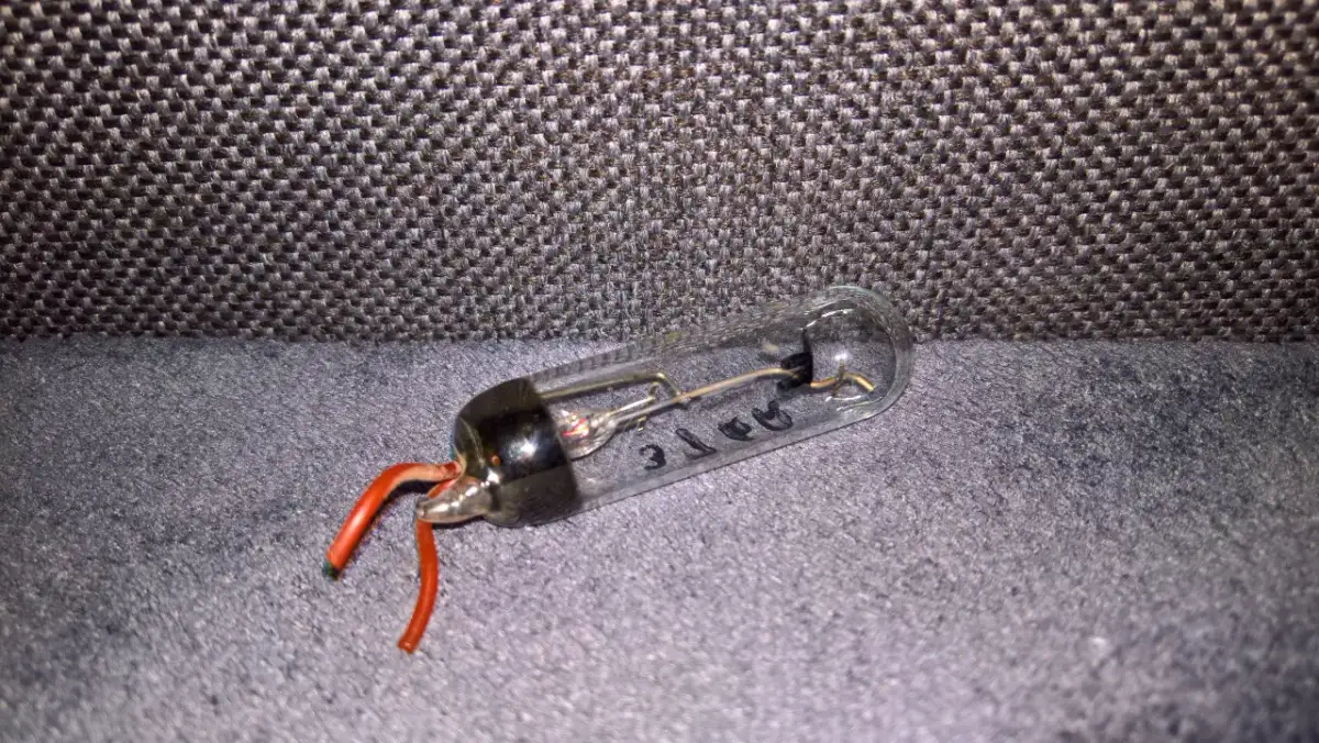 Szklana bańka z elementami elektronicznymi i czerwonymi przewodami. Tak wygląda prostownik, który kiedyś zasilał urządzenia.