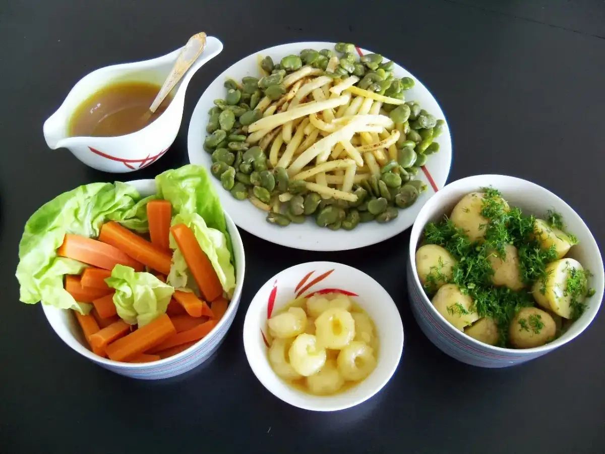 Zestaw talerzy z kluskami śląskimi, ziemniakami, fasolką, marchewką i sosem.