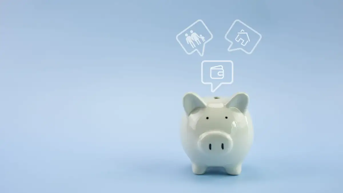 Świnka skarbonka z ikonami rodziny, domu i portfela. Czy spełniasz wakacje kredytowe kryterium dochodowe?