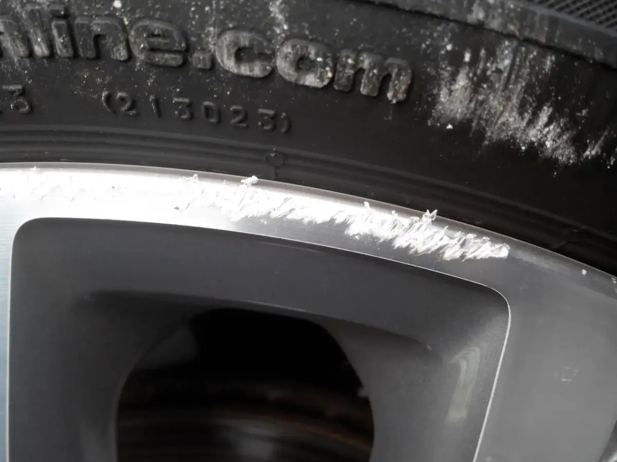 Widoczne otarcie felgi o krawężnik, ślady po nieudanej naprawie.