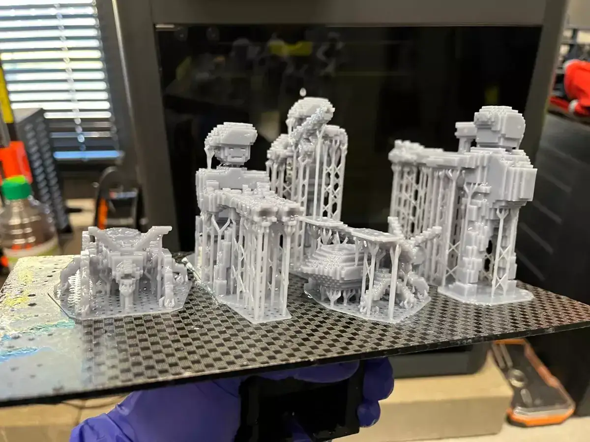 Wycena druku 3D: świeżo wydrukowane, szare figurki z żywicy, gotowe do postprodukcji.