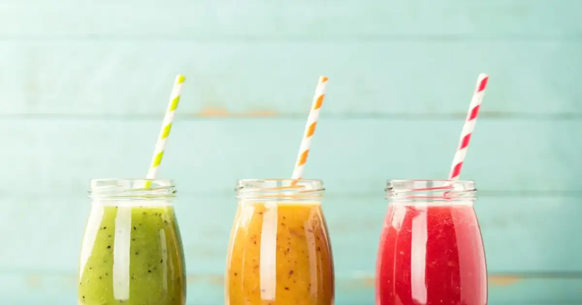 Trzy kolorowe koktajle w słoiczkach, idealne na dietę koktajlową. Zielony, pomarańczowy i czerwony napój z owoców.