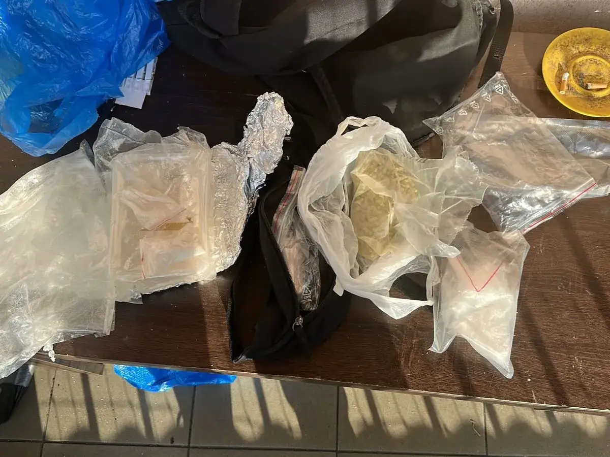 Różne substancje w foliowych i plastikowych opakowaniach na drewnianym stole.