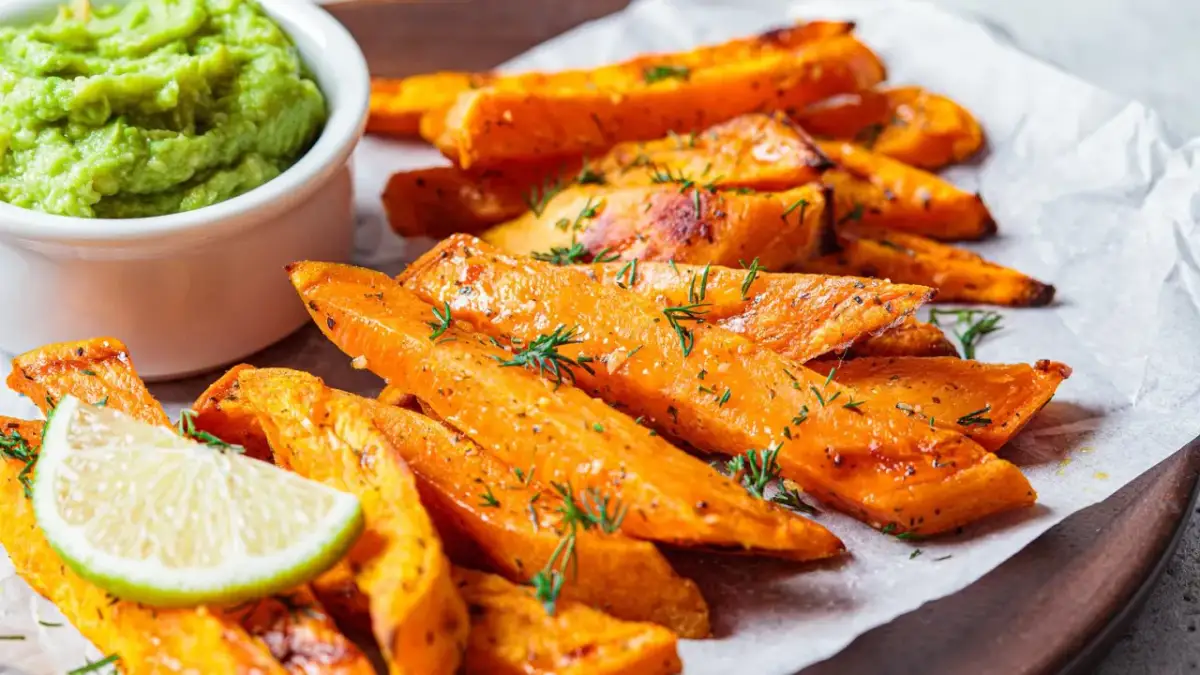 Pieczone frytki z batatów z zielonym sosem i limonką.