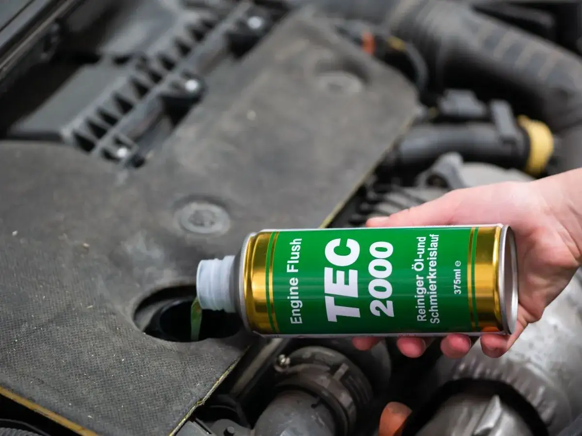 Dłoń wlewa płyn TEC 2000 do silnika. Czy płukanie silnika jest bezpieczne? To pytanie zadaje sobie wielu kierowców.