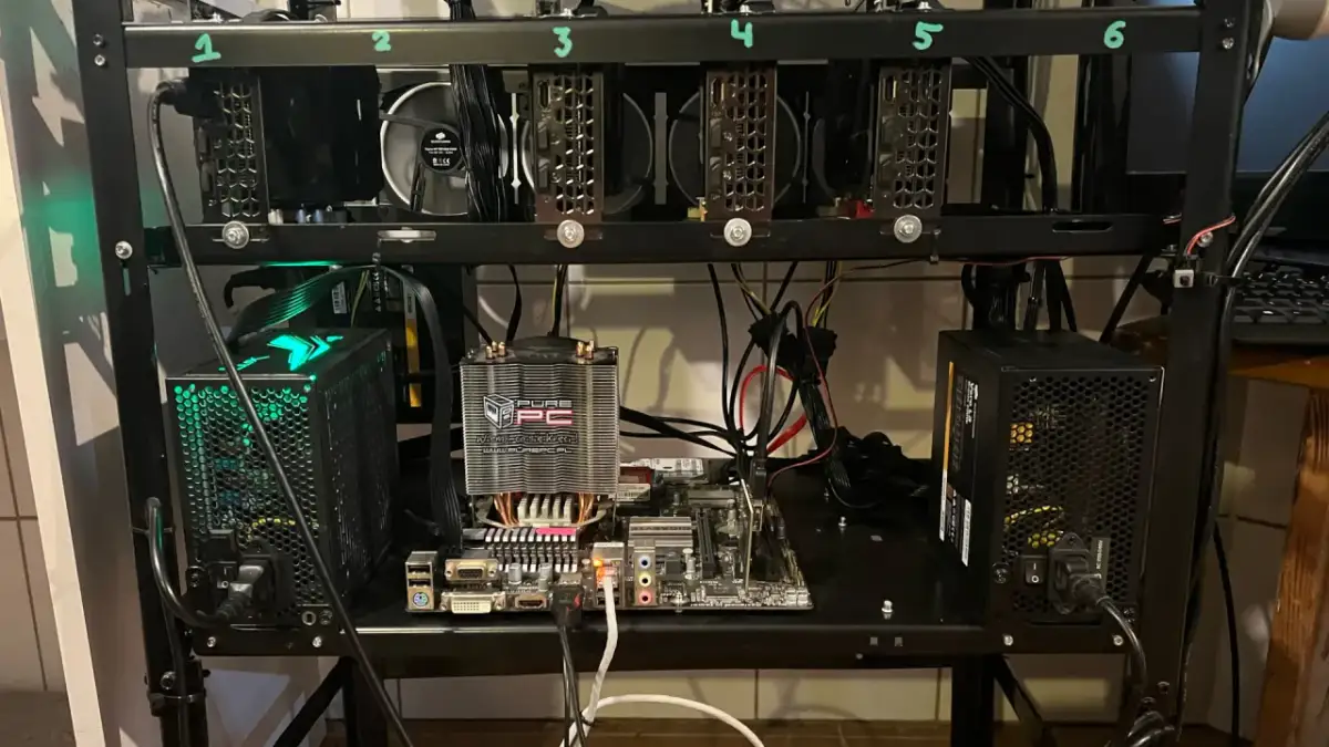 Rig do kopania kryptowaluty z sześcioma kartami graficznymi, płytą główną i zasilaczami.