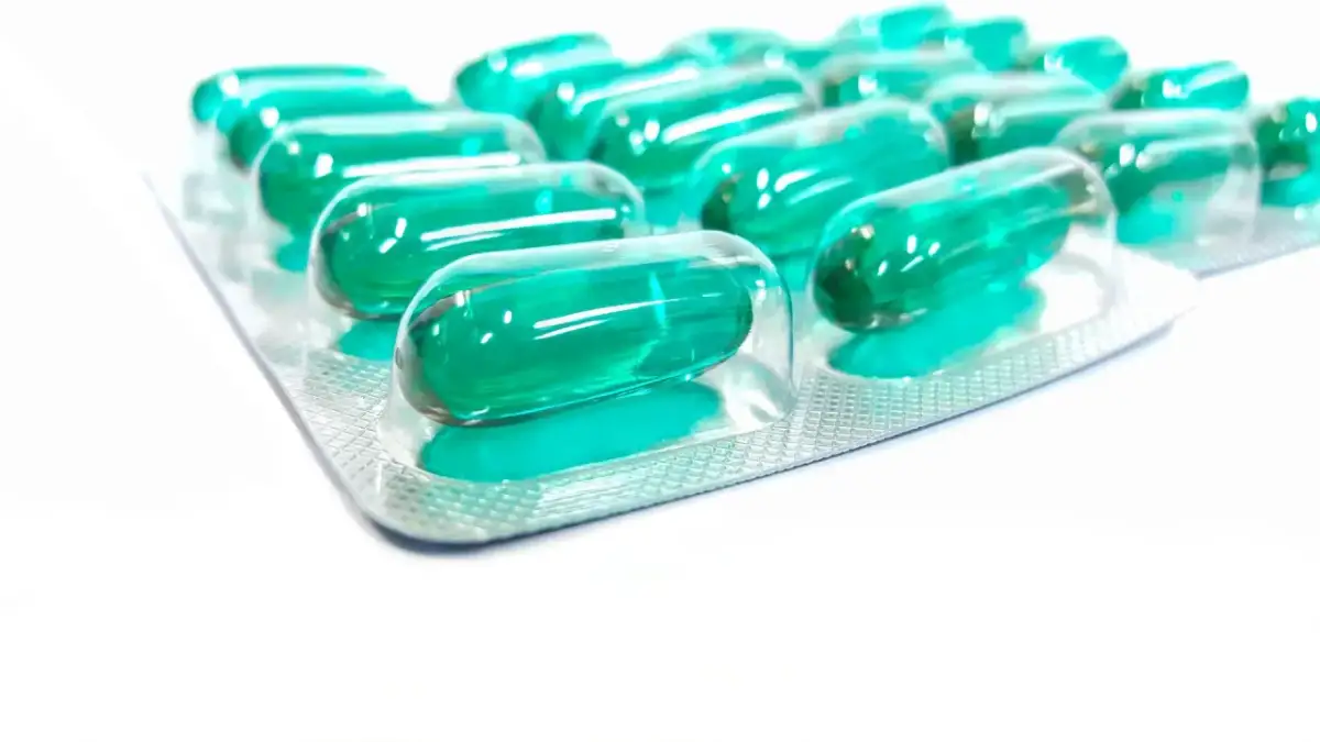 Blister opakowania z zielonymi kapsułkami. Pamiętaj o prawidłowym ibuprofen dawkowanie, by skutecznie złagodzić ból.