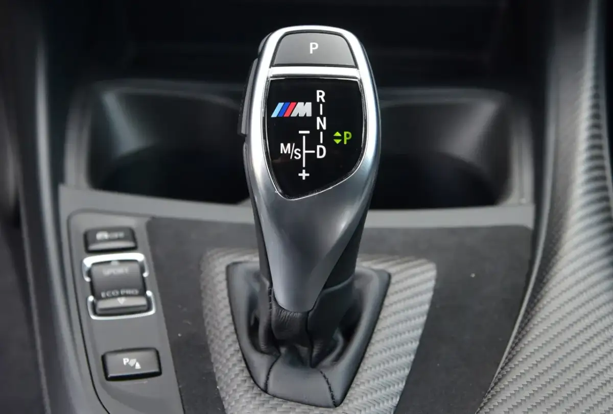 Bieg P, R, N, D, M/S na dźwigni skrzyni automatycznej BMW M. Oznaczenia biegów są czytelne.