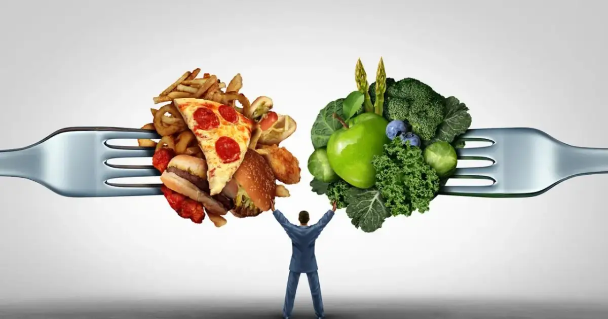 Widelec z fast foodami po lewej i warzywami po prawej, mężczyzna podtrzymuje je.
