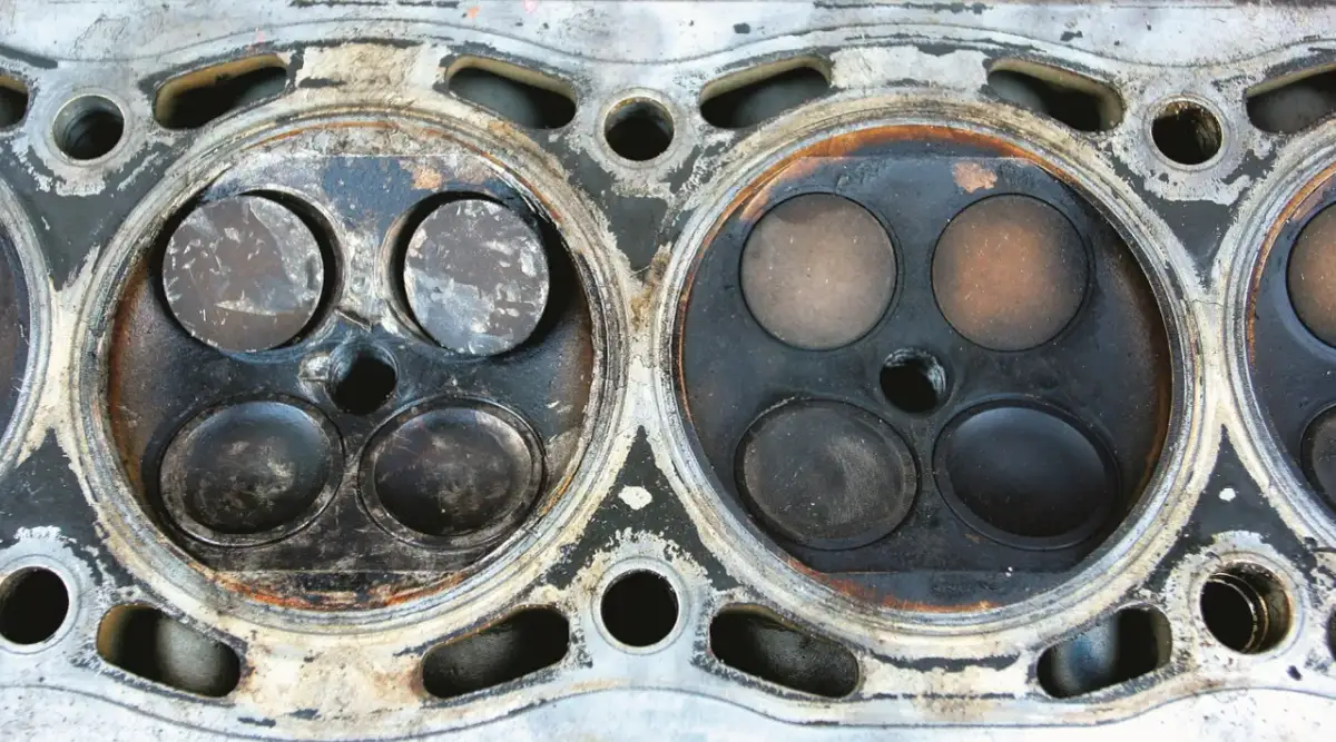 Widok głowicy silnika z widocznymi śladami zużycia. Wypalony zawór może oznaczać problemy z kompresją.